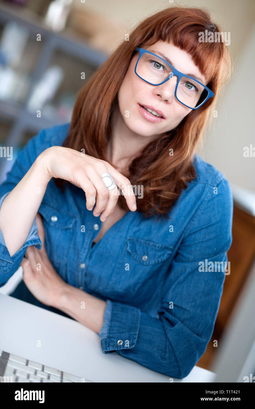 mujer de pelo rojo moderno con gafas Foto de stock
