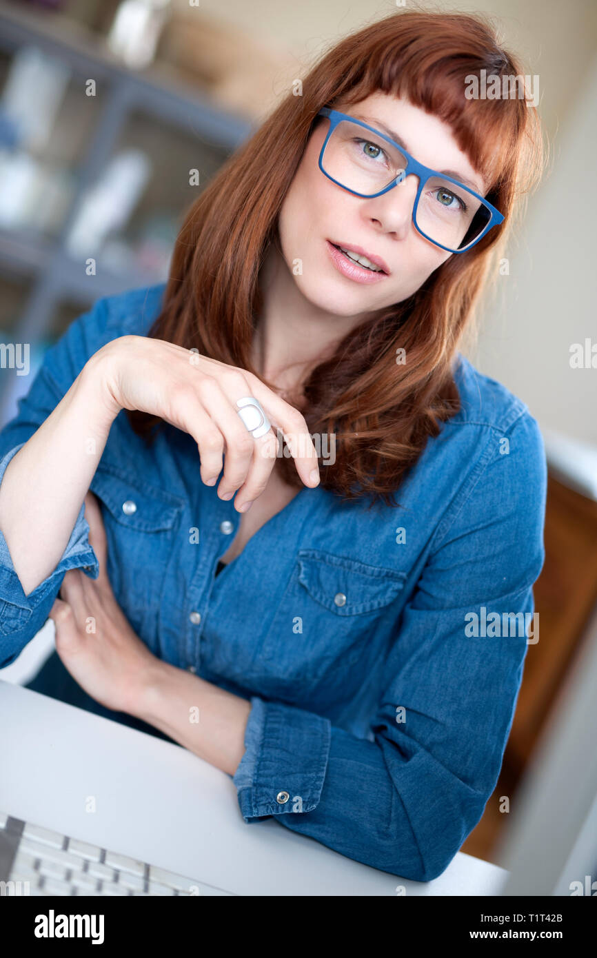 mujer de pelo rojo moderno con gafas Foto de stock