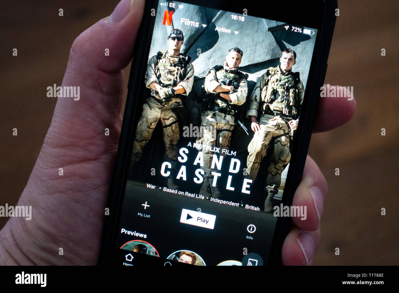 Utilizando un teléfono móvil para navegar por streaming de películas de Netflix app Foto de stock