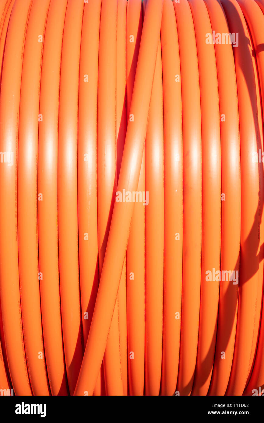 Un rollo de aislamiento plástico protector naranja para un cable de alta  tensión de una empresa de telecomunicaciones Fotografía de stock - Alamy