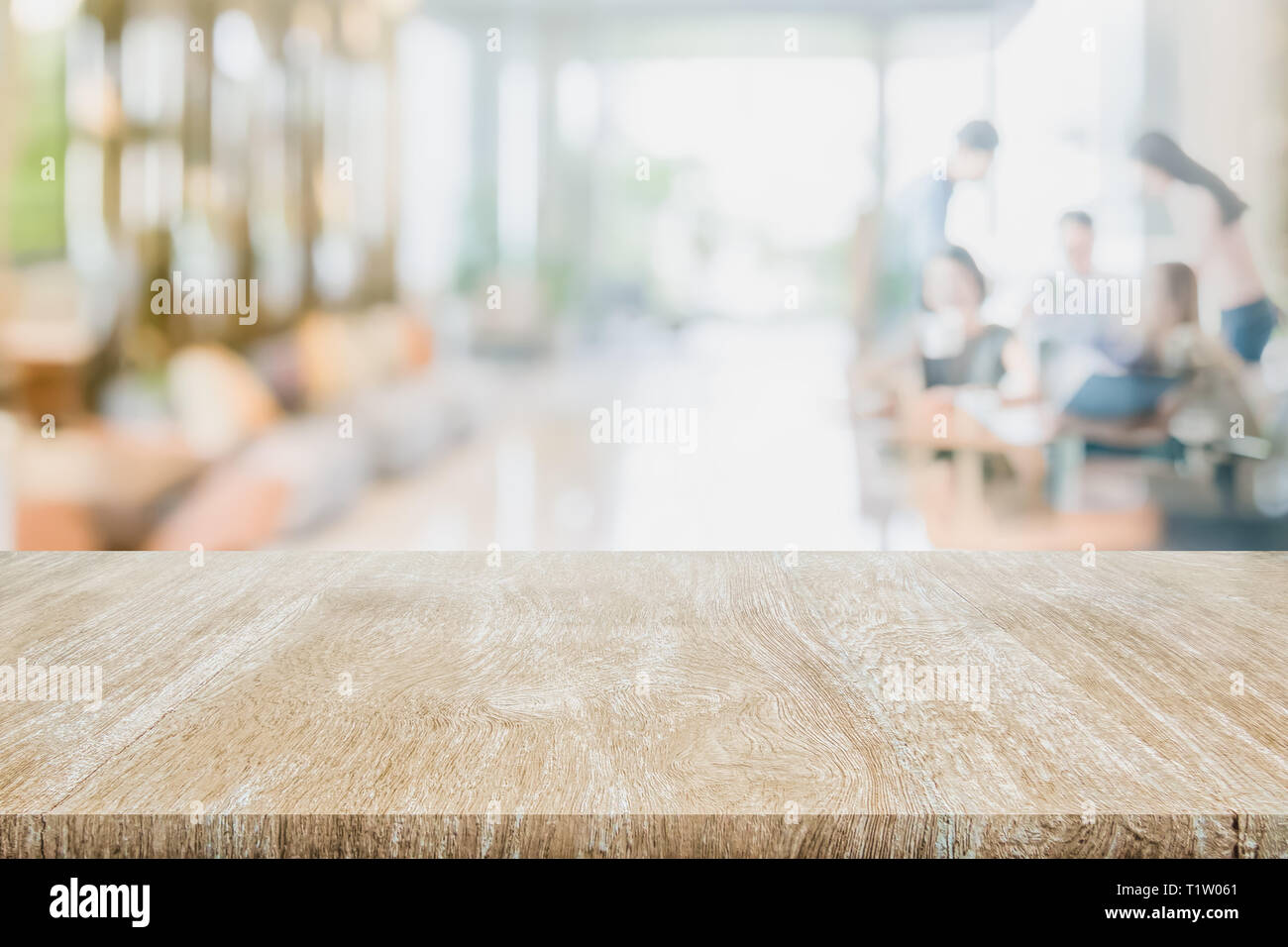 Mesa de madera en el interior la gente borrosa borrosa reunión en la cafetería Cafe co-espacio de trabajo preparado utilizado us pantalla o montage productos diseño Foto de stock