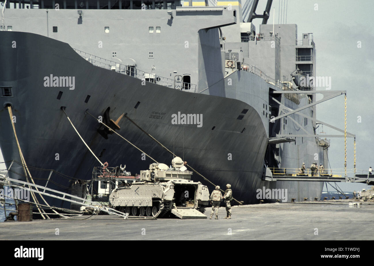 29 de octubre de 1993 el enorme buque de carga vehicular de la Administración Marina de los Estados Unidos, USNS Denebola, atracó en el nuevo puerto de Mogadiscio, Somalia. Varios soldados del ejército de EE.UU. Se encuentran en la rampa de salida del puerto y alrededor de un m2 Bradley IFV en el muelle, cerca de su arco. Otro m2 Bradley está en la popa. Foto de stock