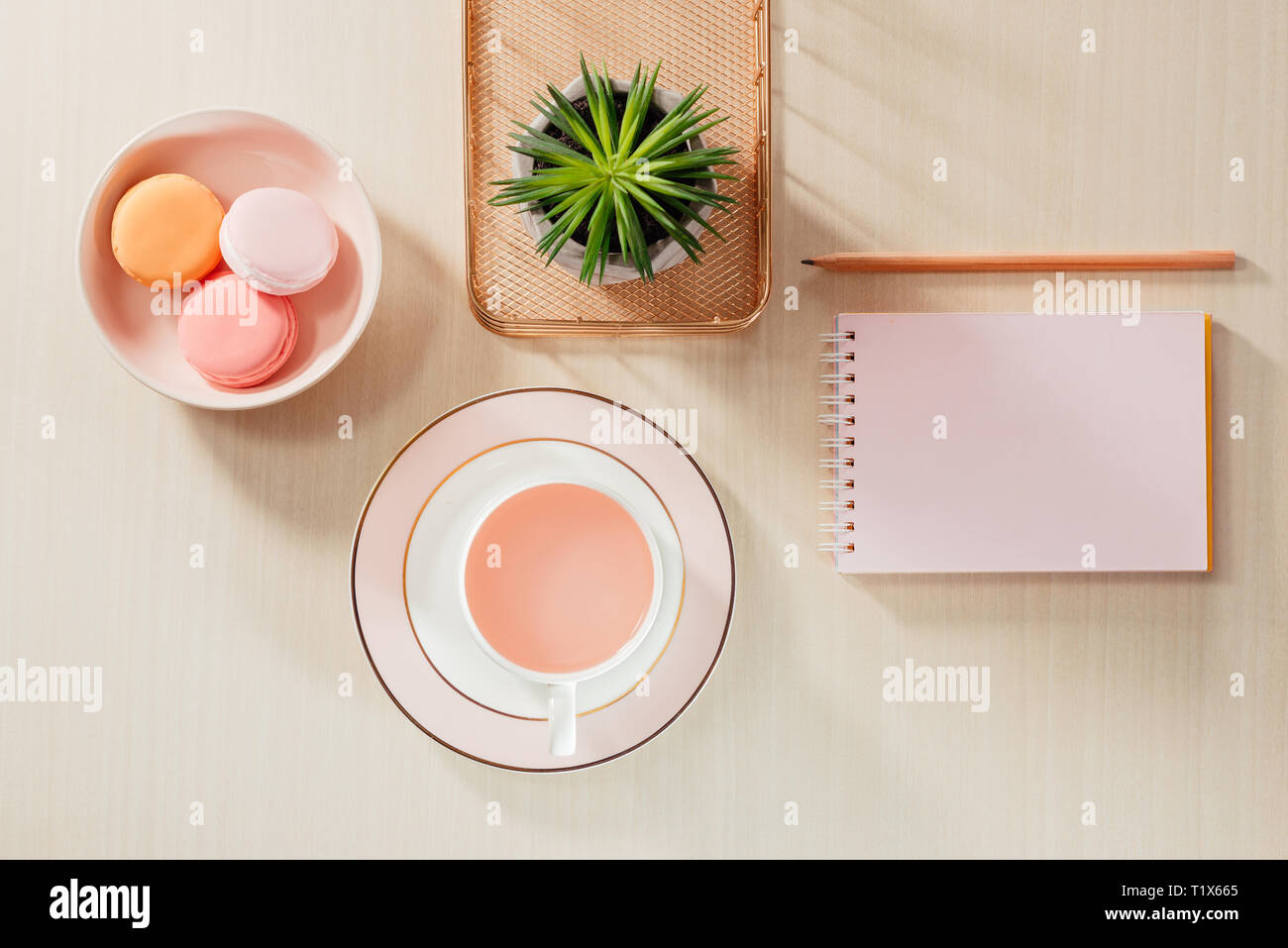 El estilo de fotografía de stock mesa de oficina de color beige con blanco, macaroon portátil, suministros y taza de café Foto de stock