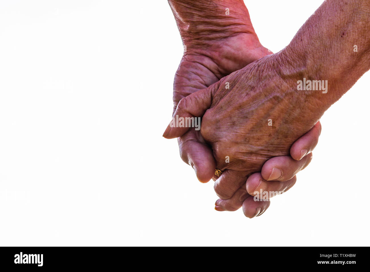 Captura recortada de la pareja de ancianos tomados de la mano exterior con fondo blanco. Se centran en las manos Foto de stock