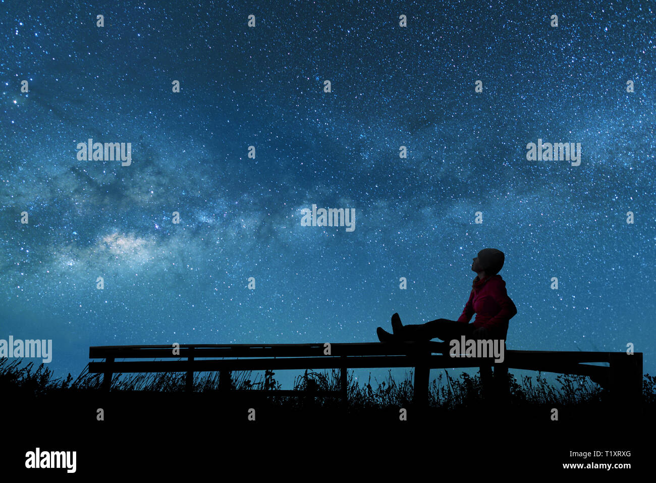 Chica observando las estrellas en el cielo nocturno Foto de stock