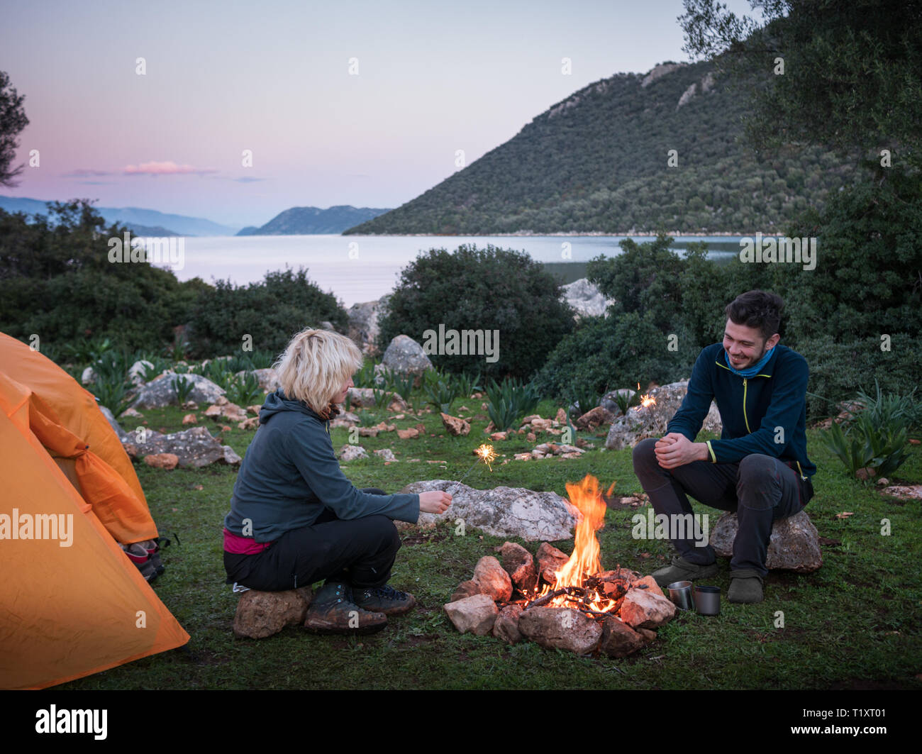 Par de camping con carpa y fogata al aire libre Foto de stock
