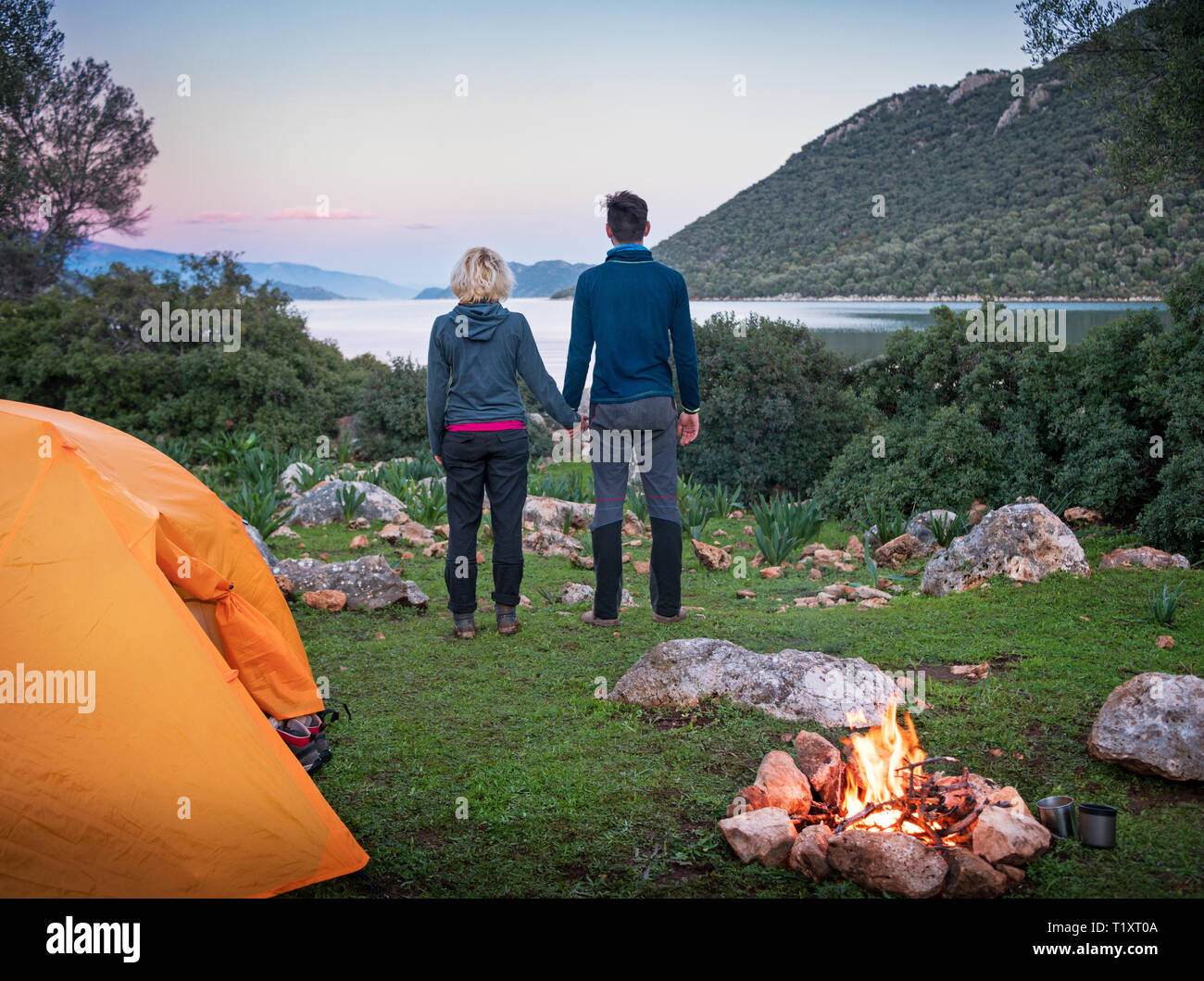 Par de camping con carpa y fogata al aire libre Foto de stock