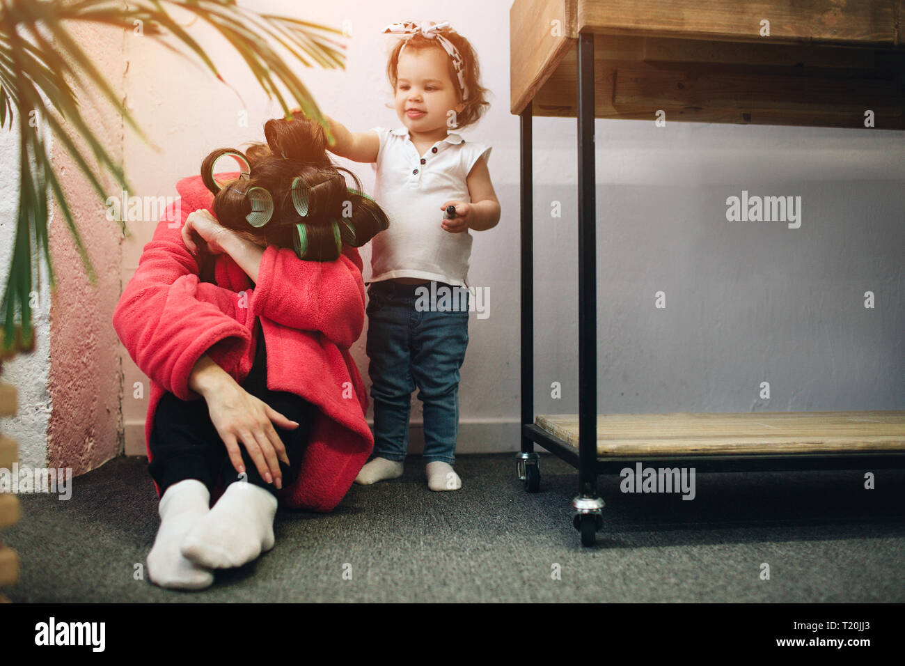 La joven madre vieja está experimentando una depresión postparto. Triste y cansada mujer con PPD. Ella no quiere jugar con su hija. Foto de stock