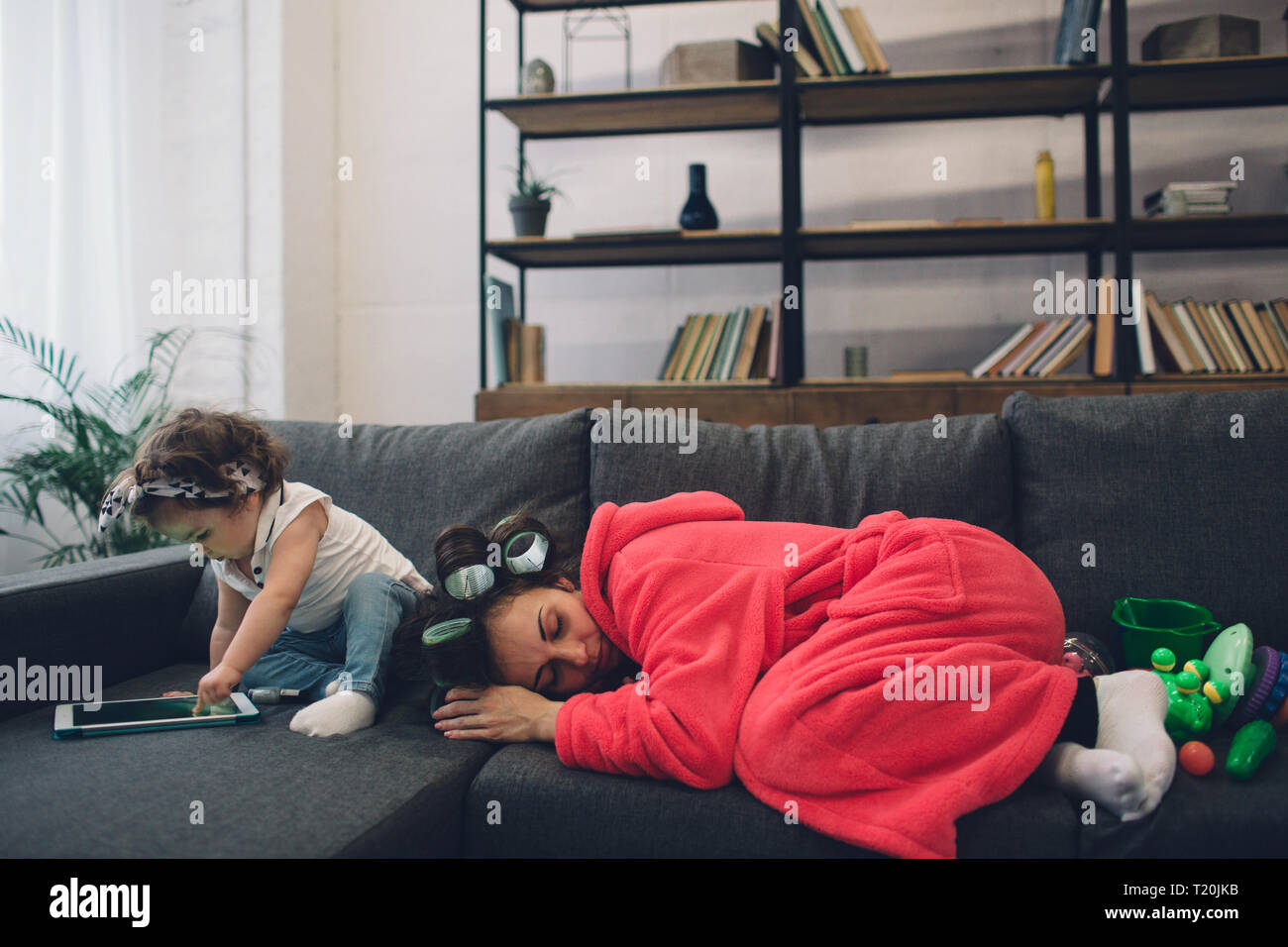 La joven madre vieja está experimentando una depresión postparto. Triste y cansada mujer con PPD. Ella no quiere jugar con su hija. Foto de stock