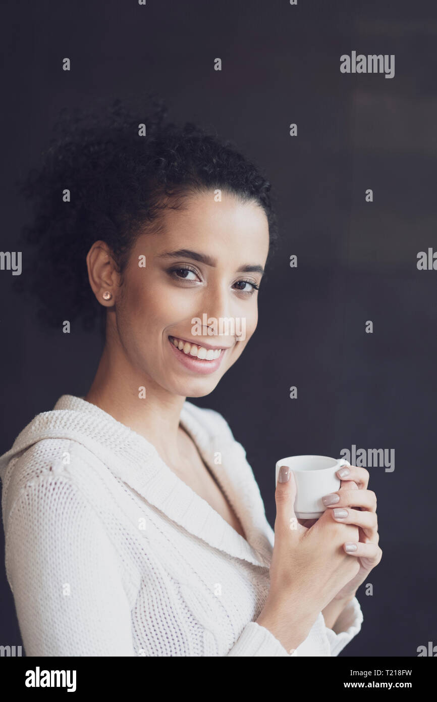 Un joven Afro Latin American Woman teniendo su coffee break Foto de stock