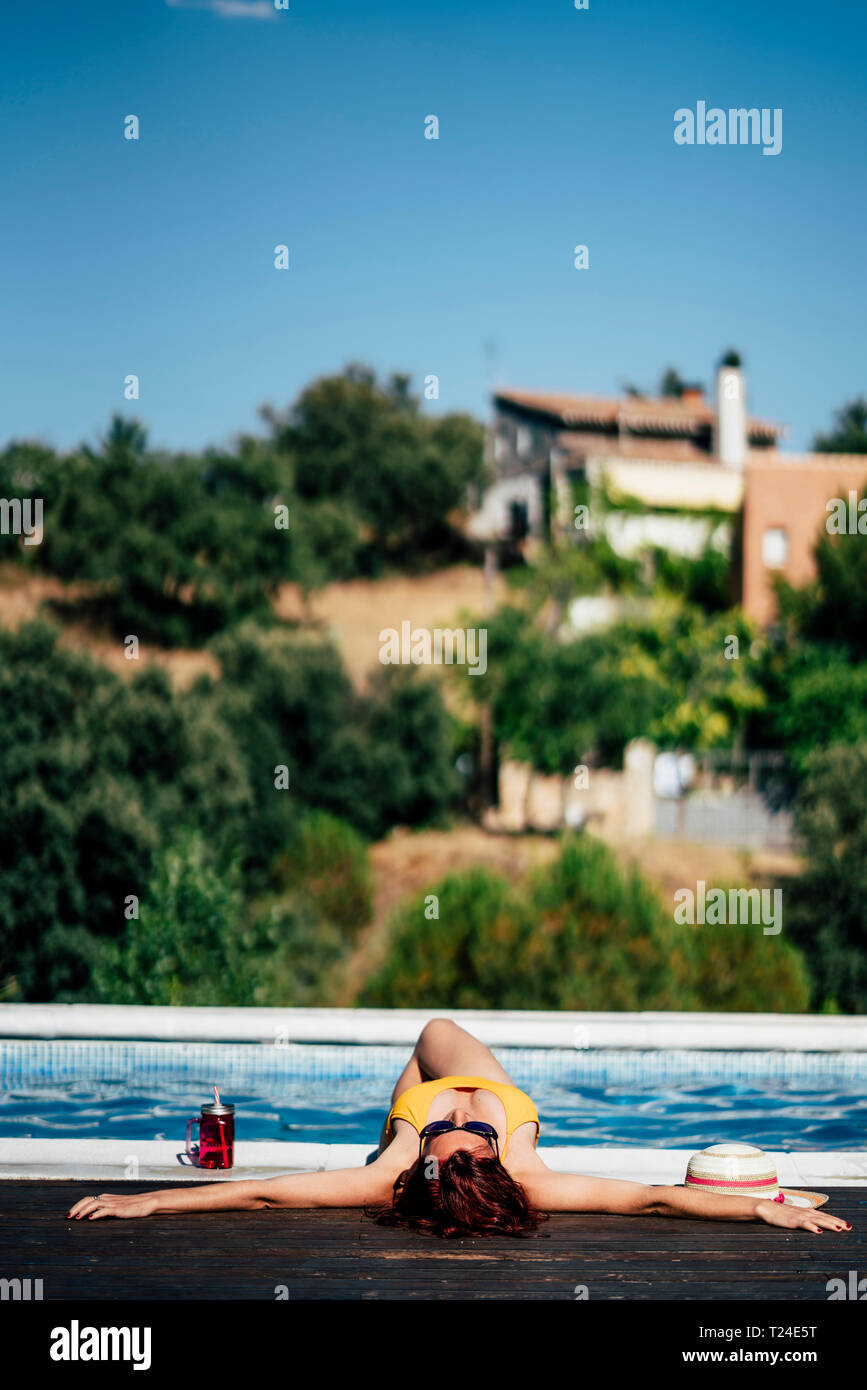 Pretty Woman en un traje de baño al lado de la piscina para tomar el sol Foto de stock