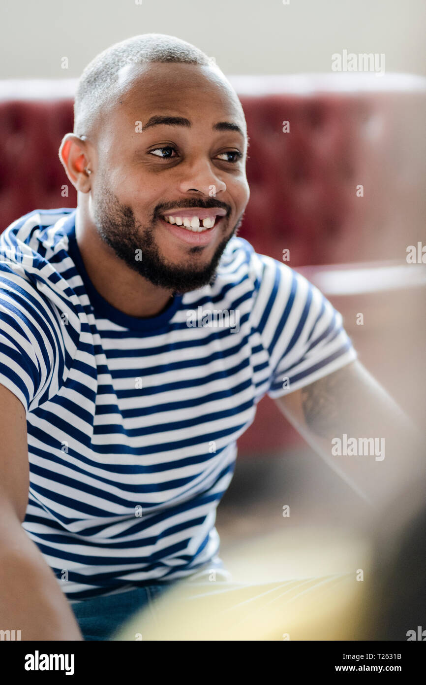 Retrato del joven sonriente vistiendo camiseta de rayas Foto de stock