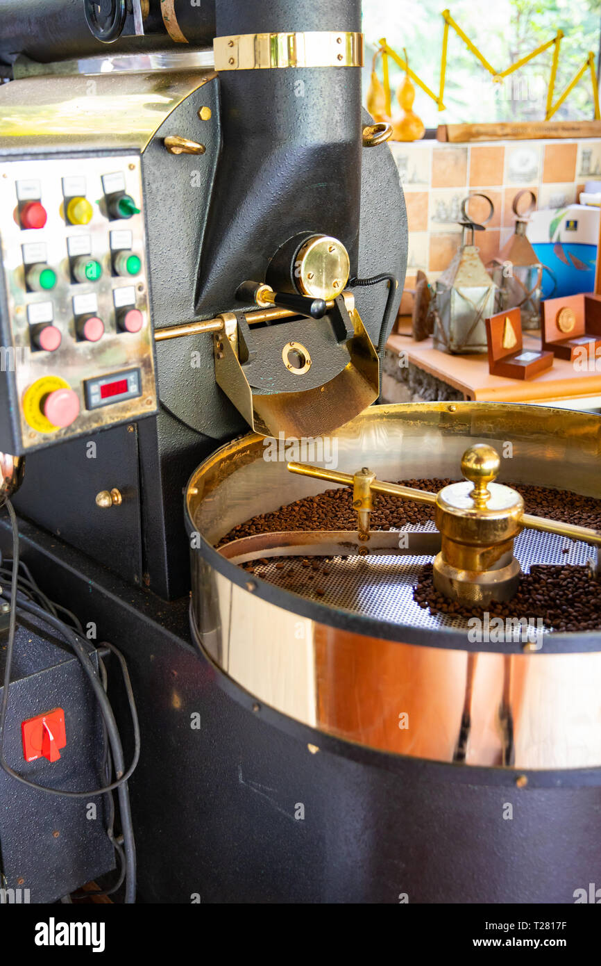 Las materias de granos de café orgánico asar en la máquina Foto de stock