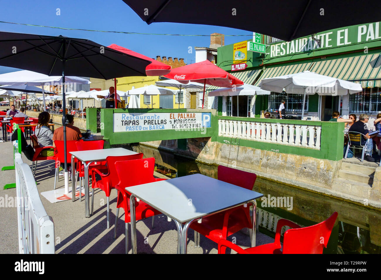 Muchos bares y restaurantes a ambos lados del canal ofrecen comida tradicional - paella y tapas, Valencia el Palmar, Parque Natural de la Albufera España Foto de stock