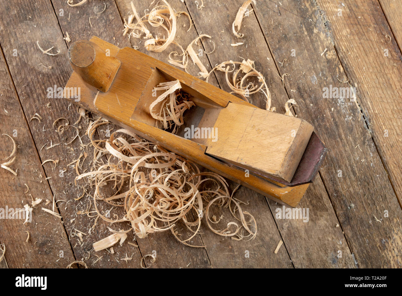 Enrasadora antiguo sobre una tabla de madera. Accesorios de bricolaje en un  antiguo taller. Fondo oscuro Fotografía de stock - Alamy