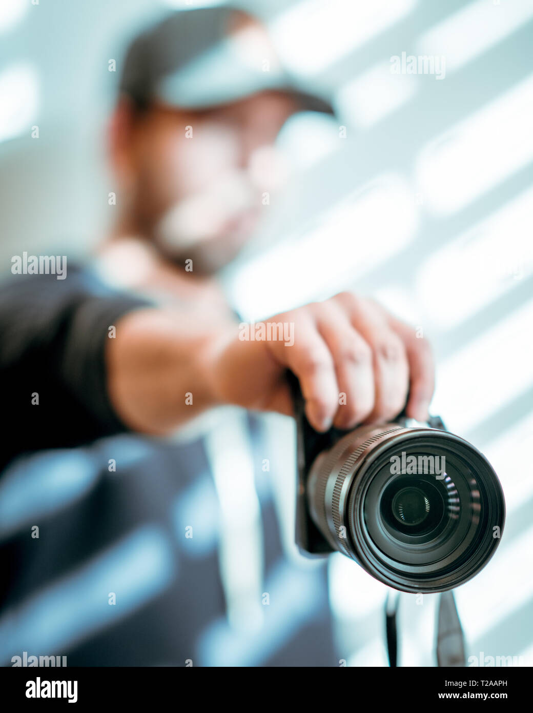Hombre manos sosteniendo la cámara fotográfica en Shady fondo blanco, espacio de copia Foto de stock