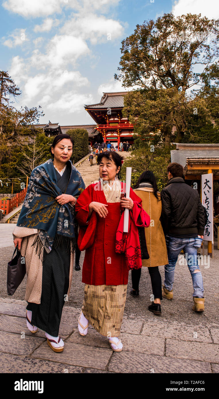 Dos mujeres que caminan hacia la cámara, templo de Tsurugaoka Hachimangu Shrine, Kamakura, Japón Foto de stock