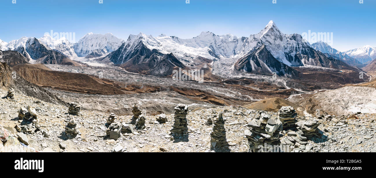 Vista desde la parte superior de la colina Chhukung sobre el Ama Dablam, Chhukung glaciar y los glaciares Imja Tse con rock cairns en primer plano, Sagarmatha, Khumbu, Nepal Foto de stock