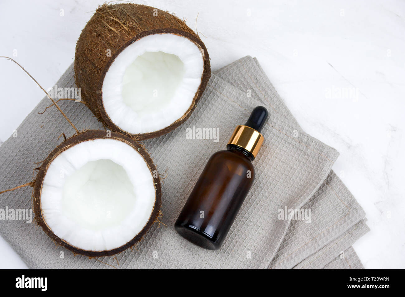 Vista superior de la botella de aceite de coco y sobre una mesa de mármol Foto de stock