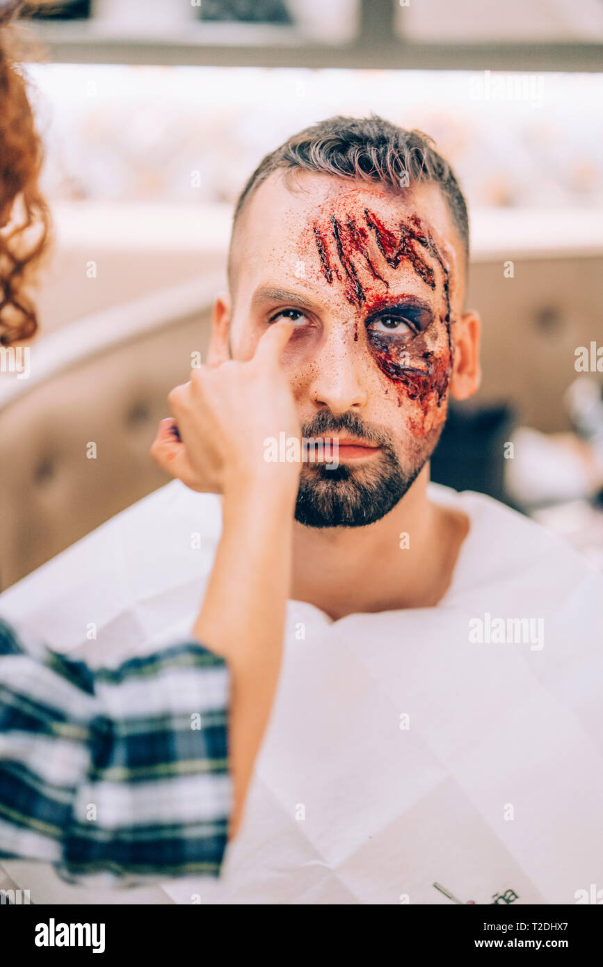 Hombre con maquillaje en la cara con heridas y sangre Fotografía de stock -  Alamy