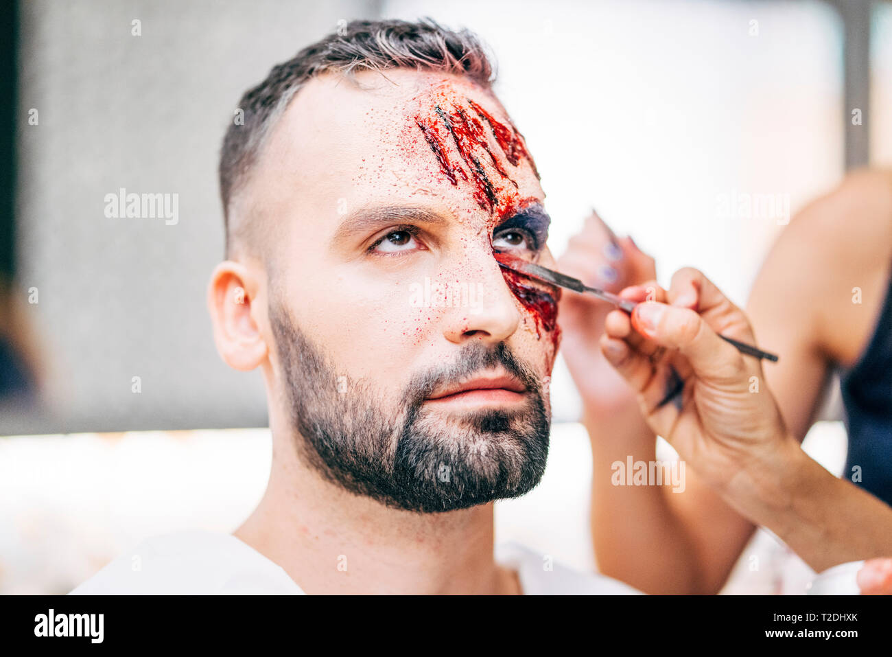 Hombre con maquillaje en la cara con heridas y sangre Fotografía de stock -  Alamy