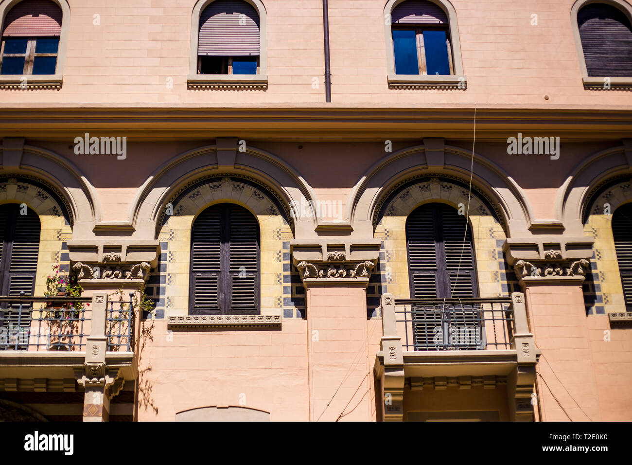 Messina, Sicilia, Italia.Un edificio de color arena con balcones con barandillas de hierro forjado. Foto de stock