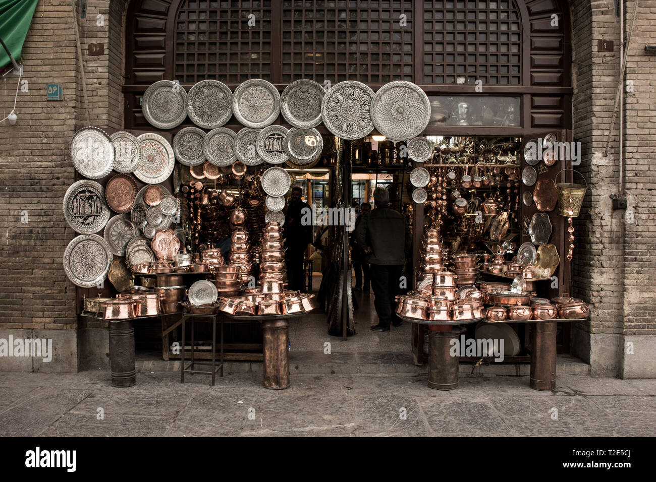 Tienda de Artesanía de Isfahan en bazar con ollas de cobre y platos en el famoso Naghshe Jahan Plaza Foto de stock