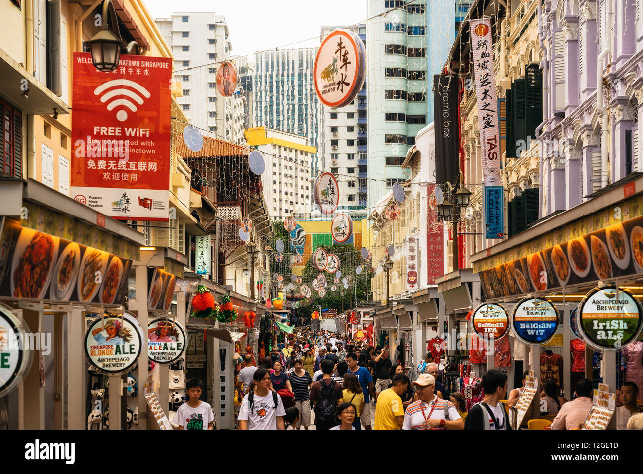 Chinatown, Singapur - Febrero 8, 2019: calle concurrida con comida callejera en Chinatown contra el Distrito Central de Negocios de Singapur Foto de stock