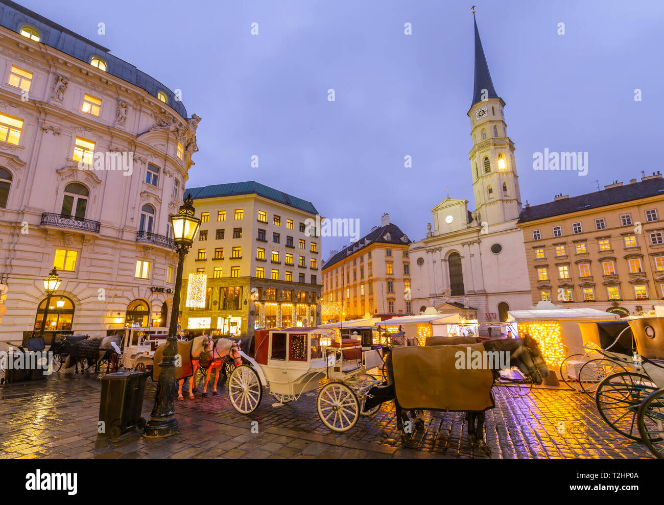 Los puestos de los mercados de Navidad y la Iglesia Católica San Miguel en la Michaelerplatz, en Viena, Austria, Europa Foto de stock