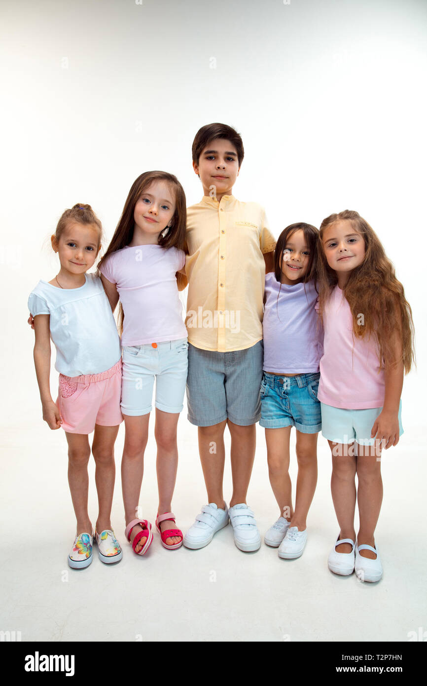 El retrato de feliz cute little boy para niños y niñas ropa informal elegante mirando a la cámara contra la blanca pared studio. Niños Moda y derechos emo Fotografía de