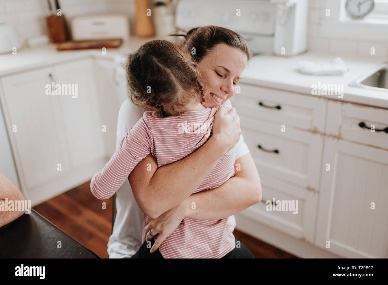 La Madre Abrazando A Su Hija En La Cocina Fotografía De Stock Alamy 