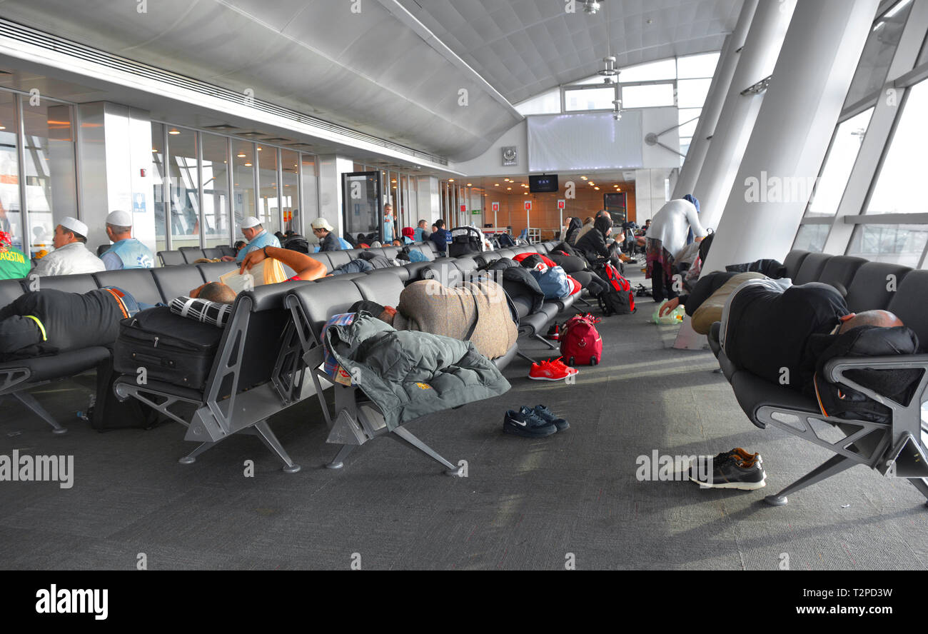 Estambul, Turquía - El 4 de enero de 2018. Los pasajeros con mucho las escalas de intentar dormir entre vuelos a una puerta en el Aeropuerto Ataturk de Estambul Foto de stock