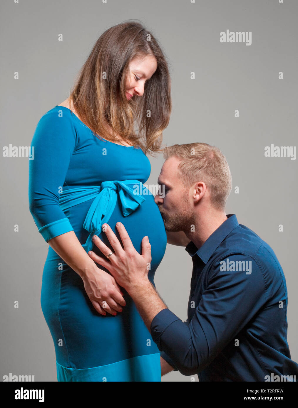 Mujer embarazada con su hombre besando el vientre. Foto de stock