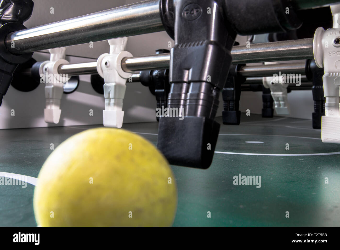 El percutor va a objetivo sobre el fútbol de mesa. El spot está en él. Él sabe que es capaz de disparar a un objetivo. Foto de stock