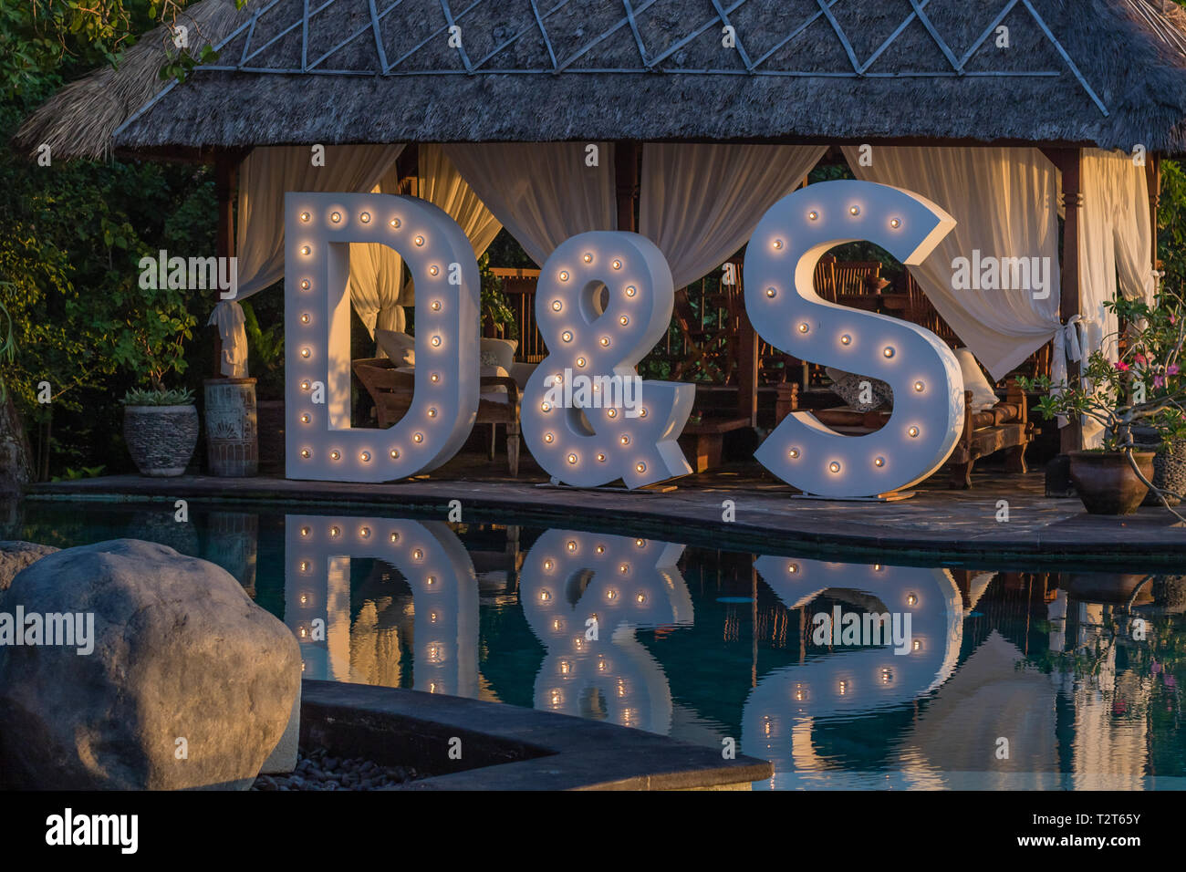 Gran boda iluminan cartas D & S cerca de la piscina con una reflexión sobre el agua. Fiesta, boda, fiesta. Foto de stock