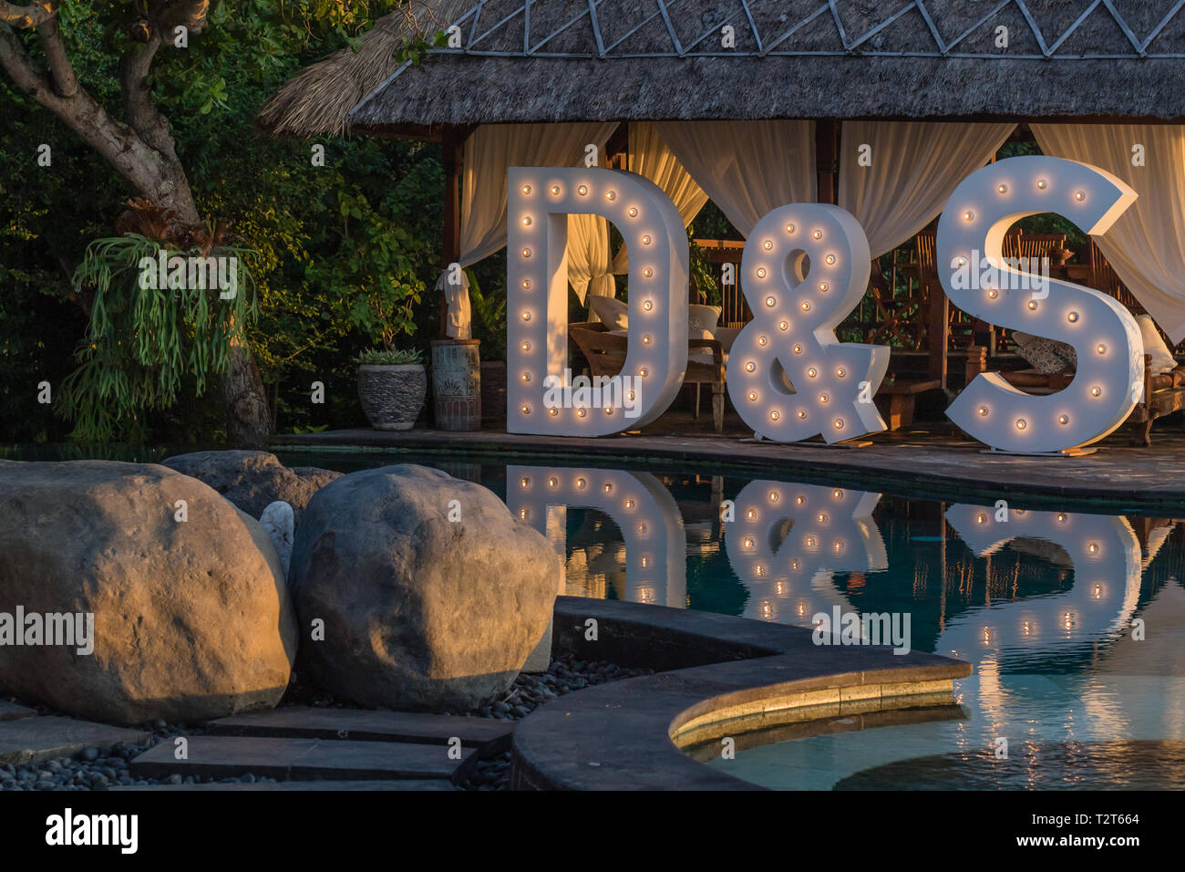 Gran boda iluminan cartas D & S cerca de la piscina con una reflexión sobre el agua. Fiesta, boda, fiesta. Foto de stock