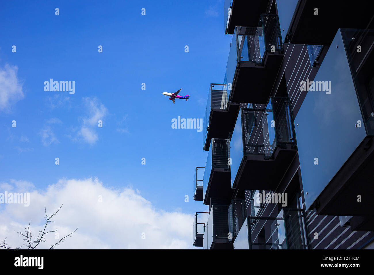 Poznan - Polonia / 16 de marzo de 2019, el avión está volando sobre nuevo edificio de apartamentos de lujo en uno de los últimos vuelos, húngaro presupuesto de aerolíneas Wizz Air Foto de stock