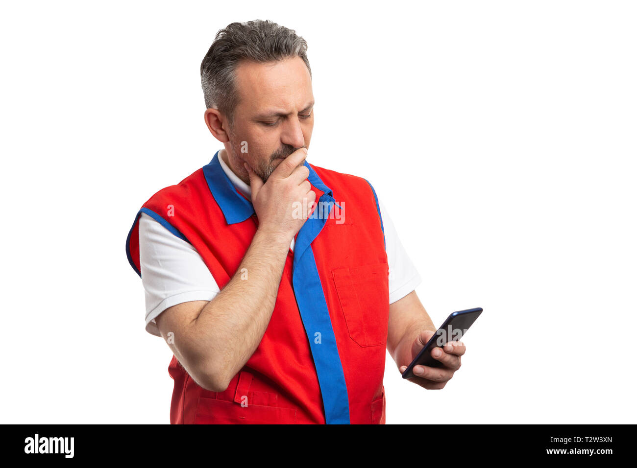 Supermercado o hipermercado masculino empleado mirando teléfono moderno centrado en la mano con expresión aislado sobre fondo blanco. Foto de stock