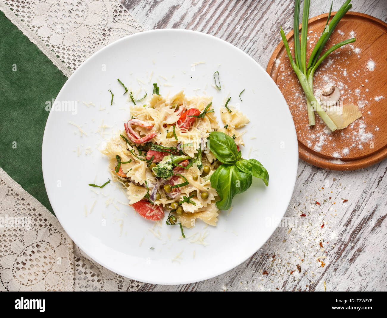 Póster para restaurantes. Ensalada con pasta, gambas, guisantes y decorado de hierbas. Sobre un fondo claro. Flay laical. Vista superior Foto de stock
