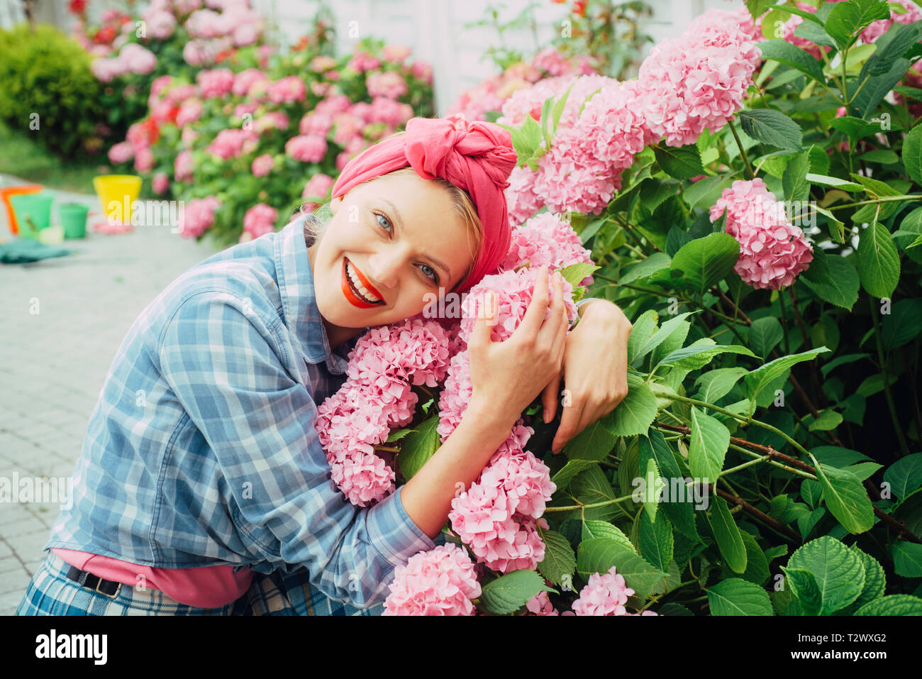 Hortensia. La primavera y el verano. Cuidados de flores y riego. suelos y  fertilizantes. mujer alegre y jardinero con flores. Mujer Cuidado de flores  en el jardín. Gre Fotografía de stock -