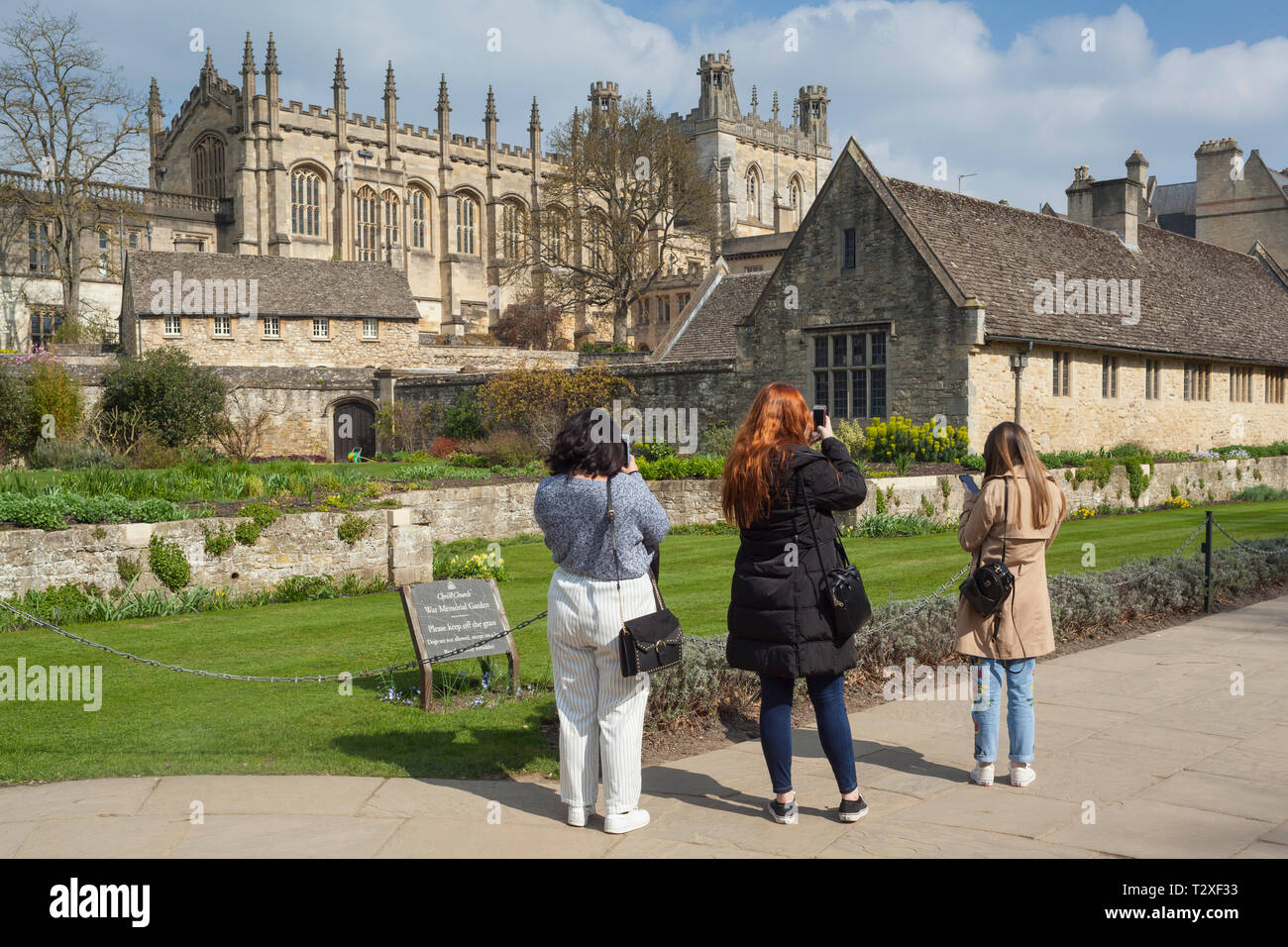 Tres mujeres jóvenes turistas fotografiar la Iglesia Catedral de Cristo, Oxford en el War Memorial Gardens Foto de stock