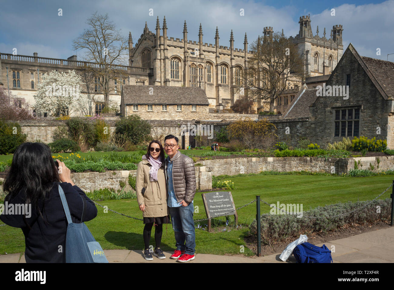 Los turistas extranjeros toman fotografías de la Catedral de la Iglesia de Cristo, Oxford, a través de los Jardines Conmemorativos de la Guerra Foto de stock