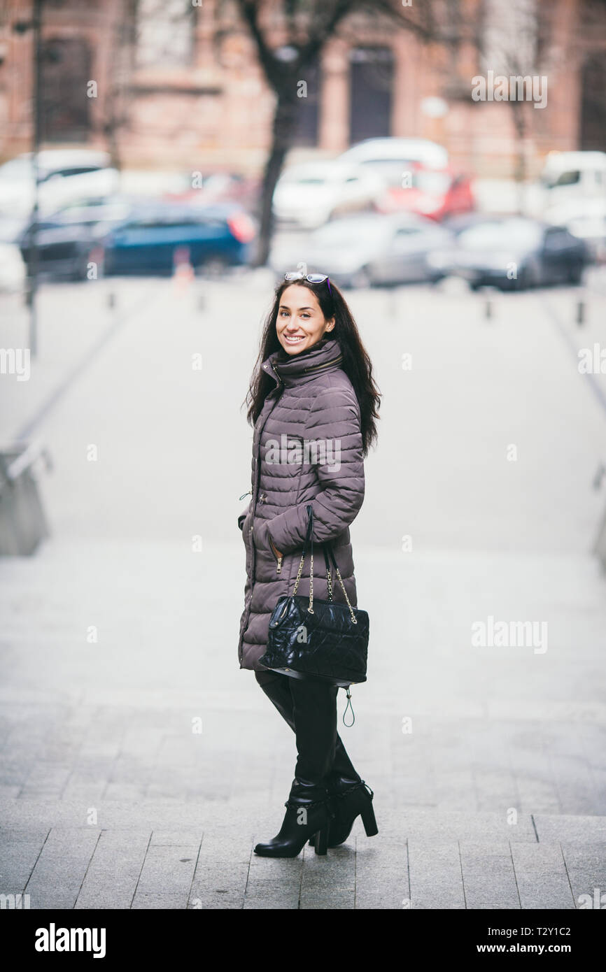 Elegante y atractiva mujer posando en la calle de moda en ropa, sosteniendo  suede handbag, vistiendo chaqueta y botas altas, primavera otoño estilo  Fotografía de stock - Alamy