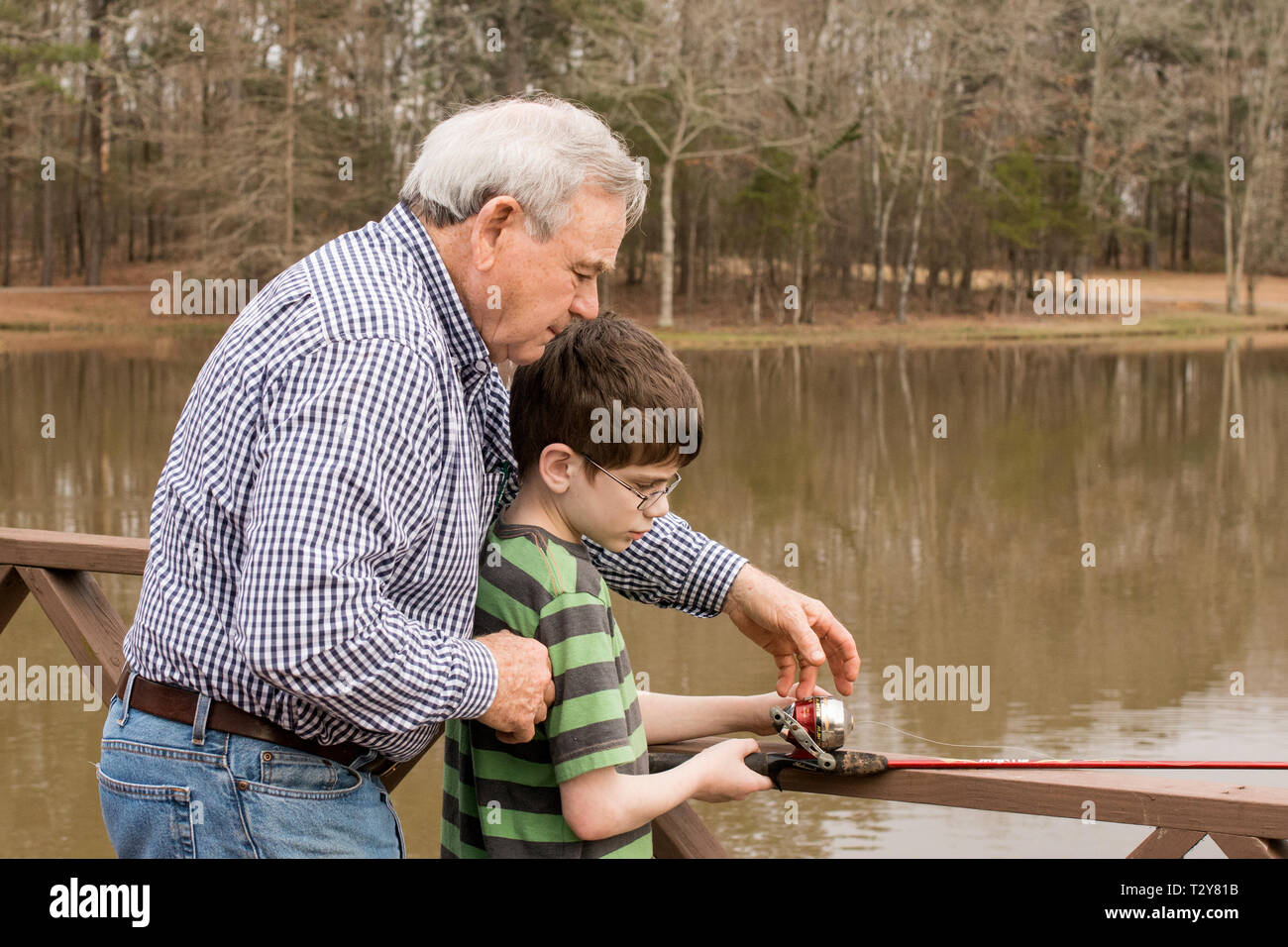 Un niño de 11 años de edad, aprender a pescar con su abuelo en un lago en Madison, Mississippi, Estados Unidos. Foto de stock