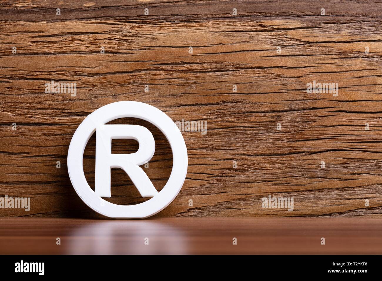 Signo de marca registrada en frente de la pared de madera Foto de stock