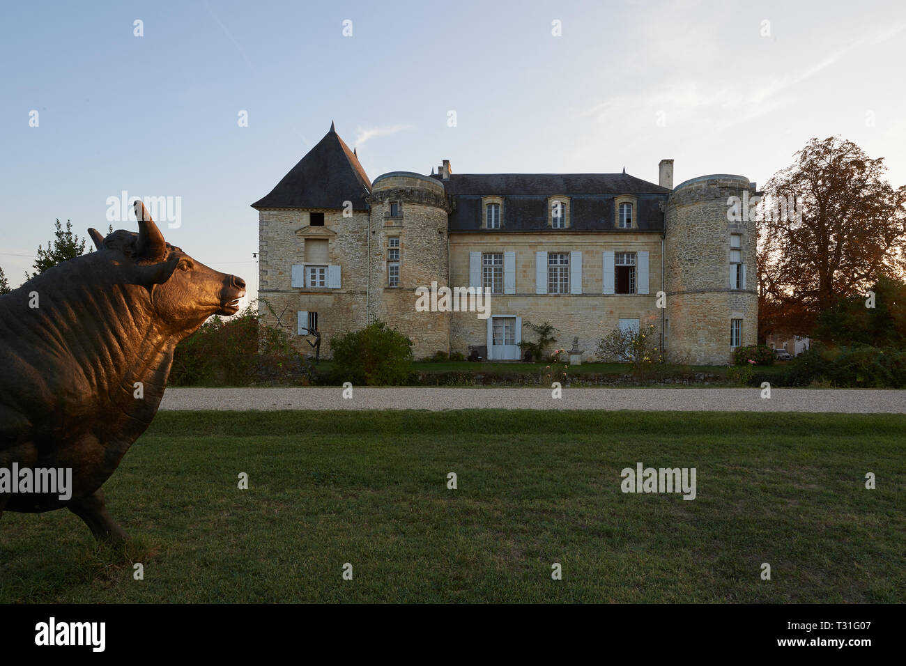 El hermoso Chateau de Lescours con su firma bull estatua iluminada por el sol. Foto de stock