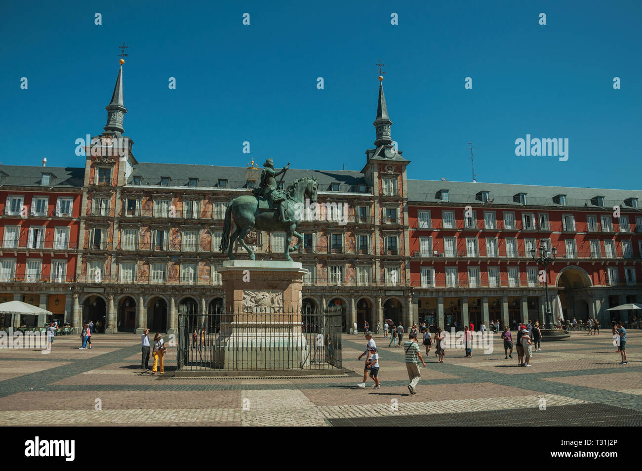 La gente en la Plaza Mayor, rodeada por el antiguo edificio con grandes balcones en Madrid. Capital de España, vibrante y con una intensa vida cultural. Foto de stock