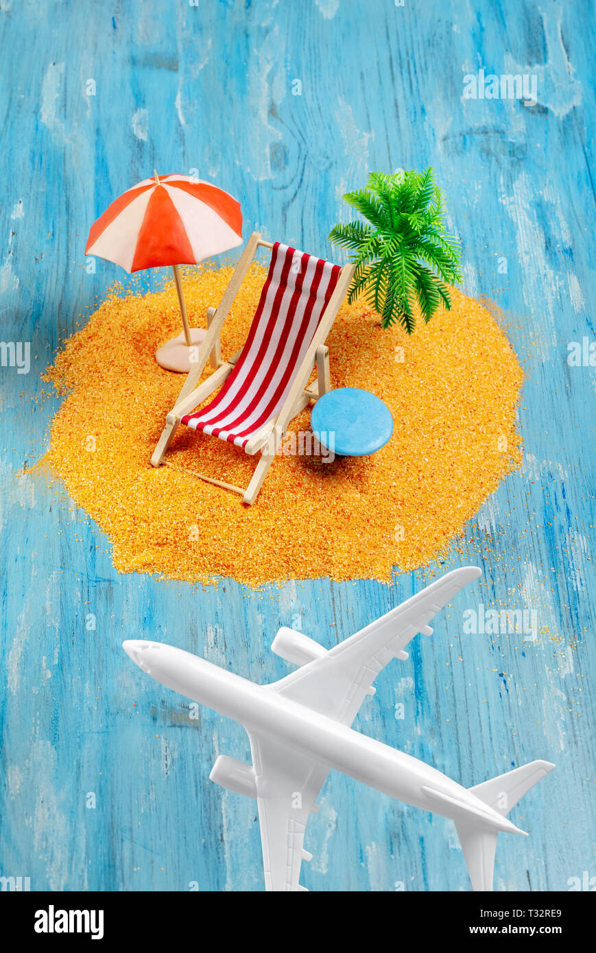 Aviones y Dream Island. Playa en miniatura con tumbona y sombrilla de palm,  sobre fondo azul. Vacaciones y viajes exóticos concepto Fotografía de stock  - Alamy