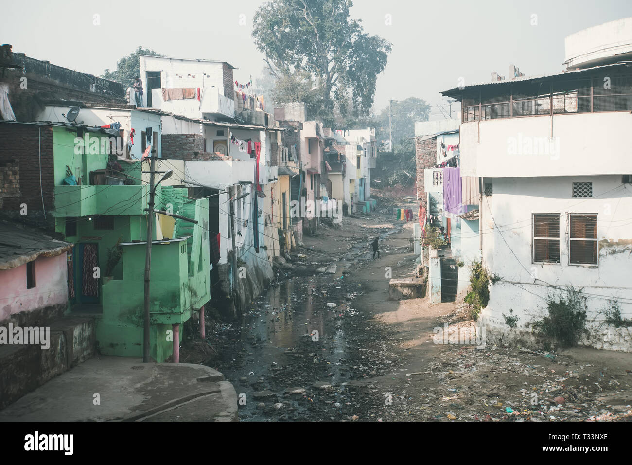 Un flujo de aguas residuales pestilente en las barriadas. Zona pobre de Haridwar, India. La gente pobre de la casa en la colina delante de un río sucio de nuestros problemas sociales. Foto de stock