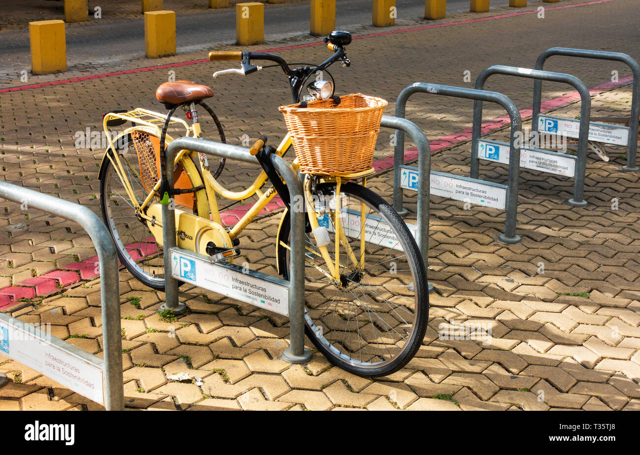 La bicicleta de una mujer con una cesta de compra adjunta en un espacio de  estacionamiento de bicicletas en Sevilla Fotografía de stock - Alamy